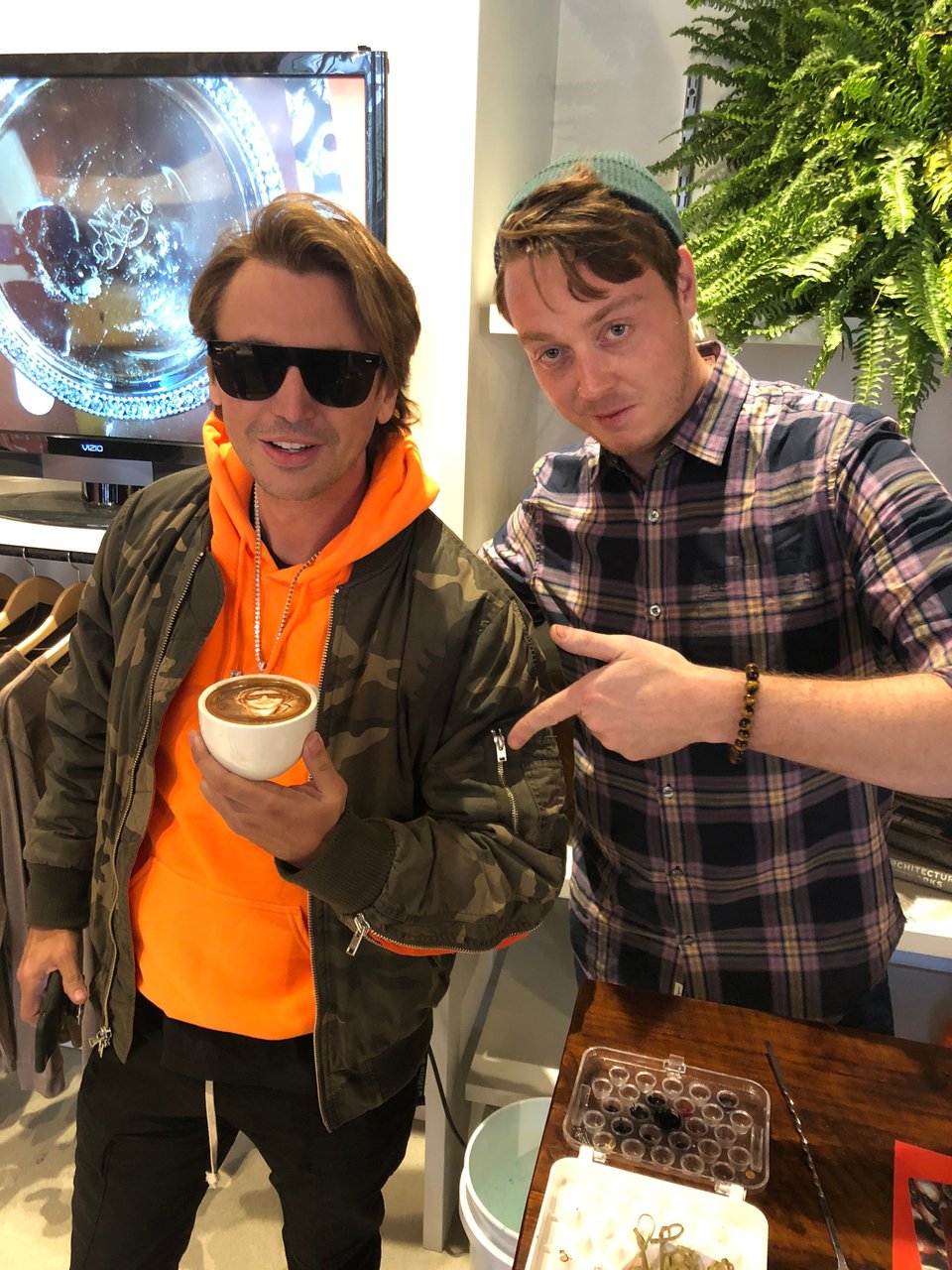 Coffee artist Michael Breach poses with Jonathan Chiban and his latte art.