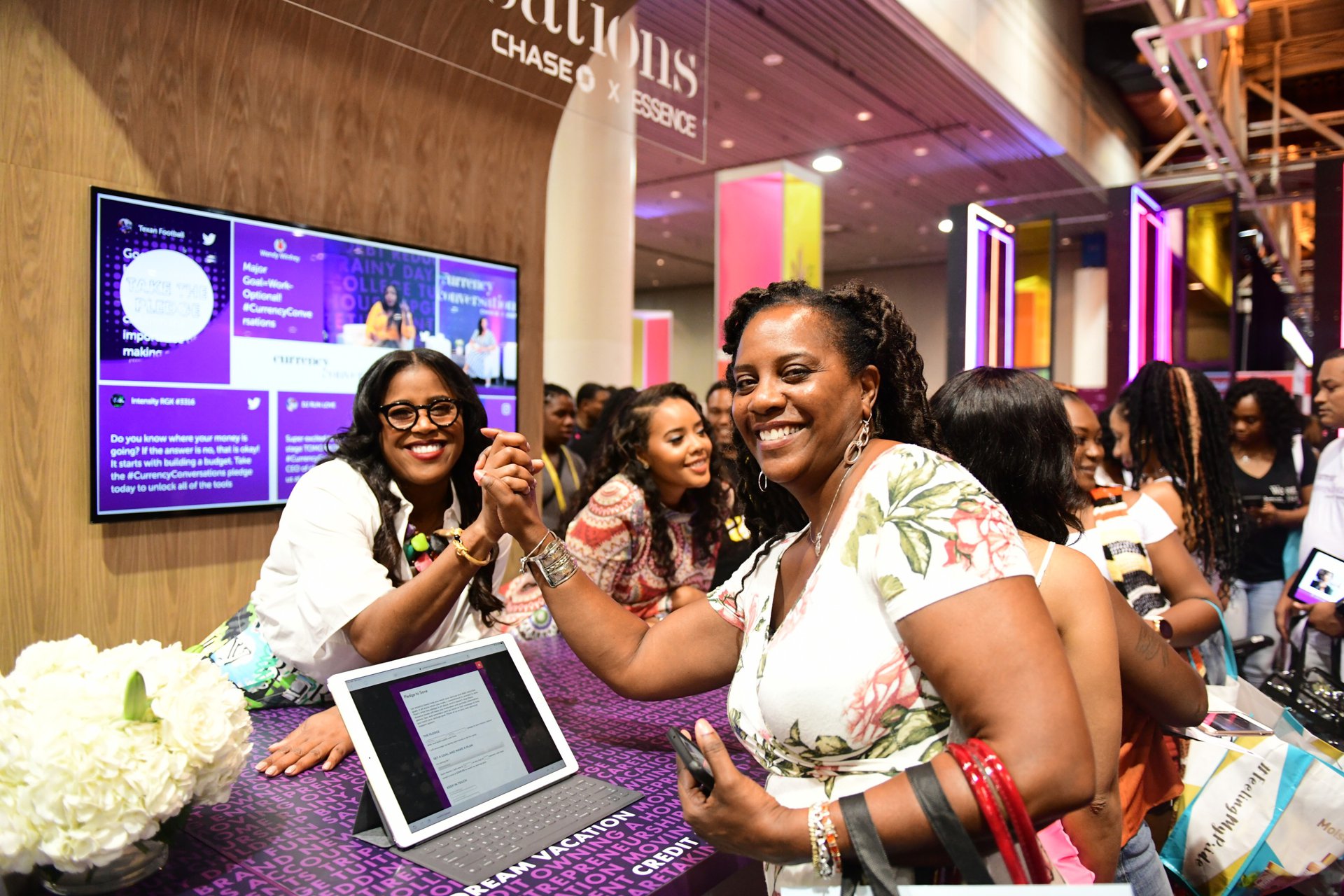 Two women pose after taking financial pledges at Chase Currency Conversations.