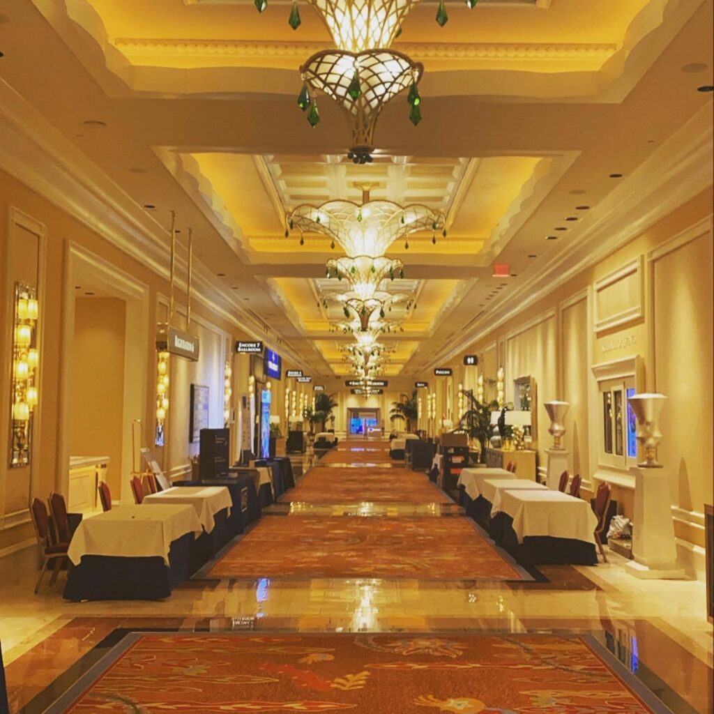 A large hallway at a conference with tables lining the walls