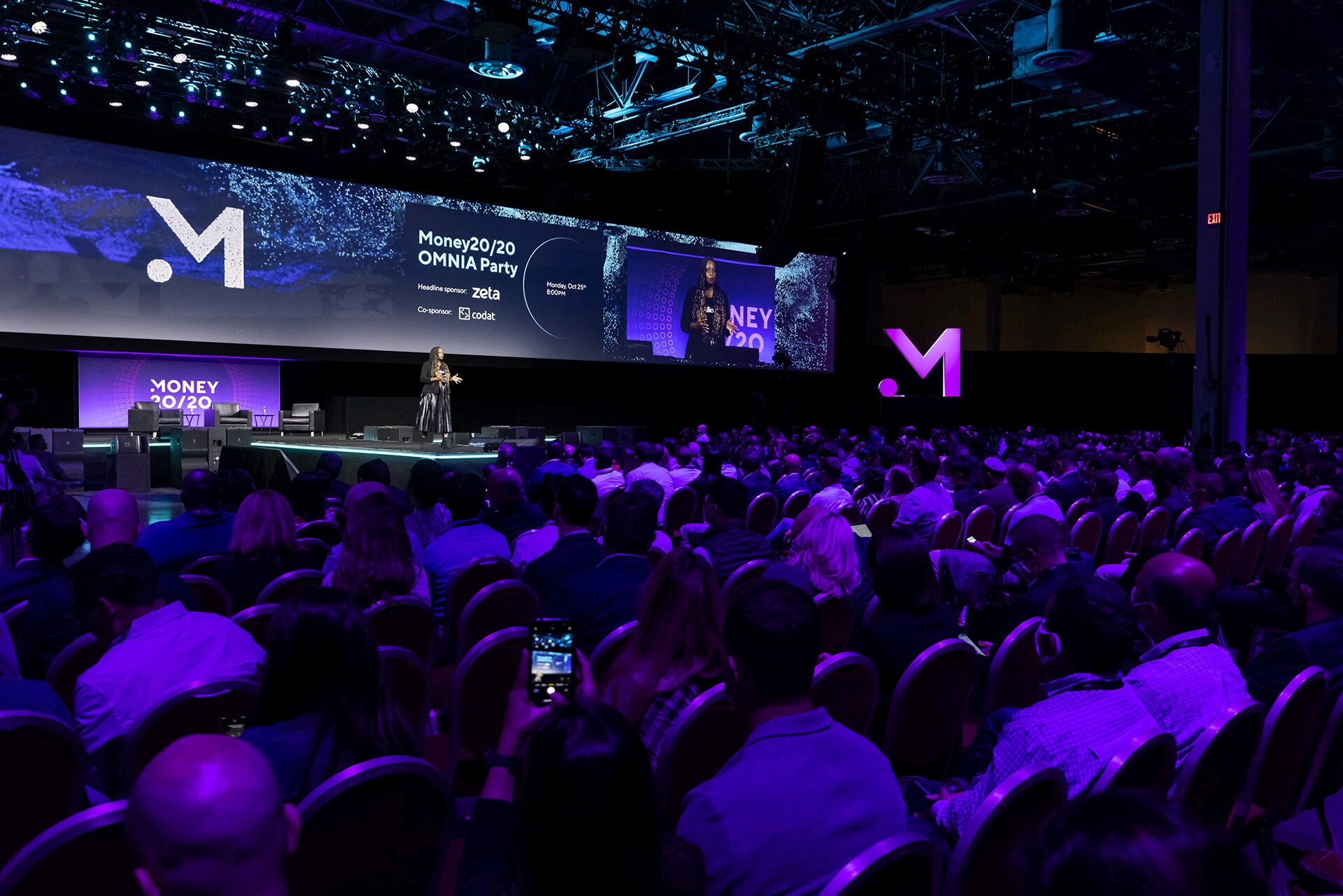 Large audience and stage with purple stage lighting.